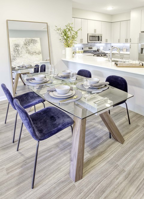 a contemporary dining room with a glass table and purple chairs at The Enclave, Jersey City, NJ, 07310